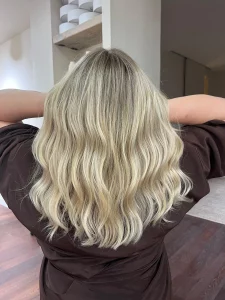 Mujer con melena rubia luminosa Airtouch balayage en peluquería Mataró La Están Peinando antes después